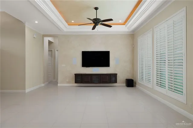 a living room with a flat screen tv and a ceiling fan