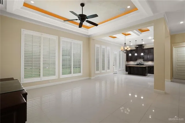 a view of an empty room with a window and kitchen view