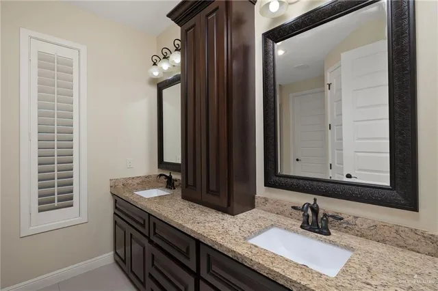 a bathroom with a granite countertop sink and a mirror