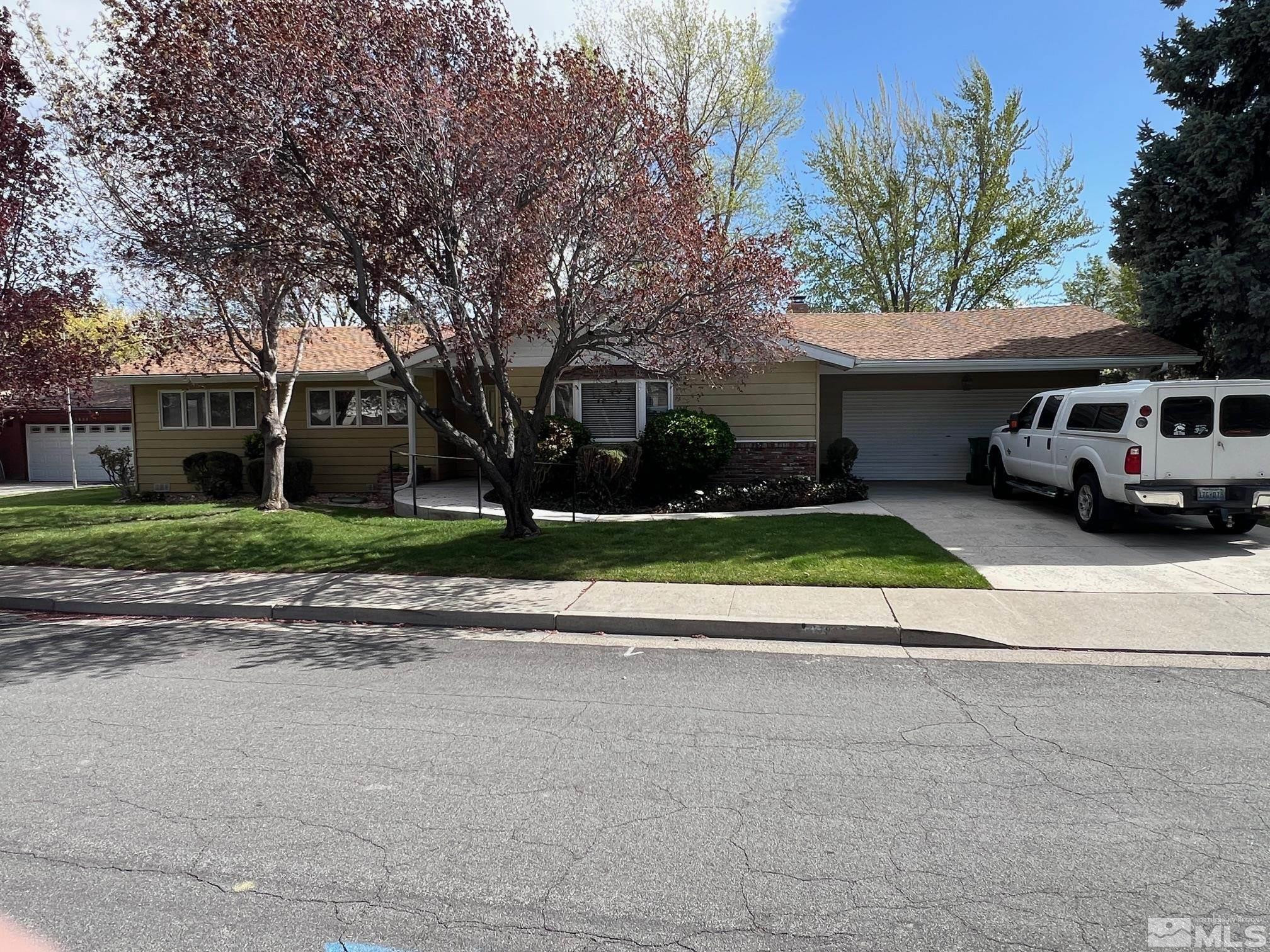 1840 Allen Street Reno, NV 89509 - Photo 1 of 20 a view of a white house with a large windows and a yard with plants and large trees