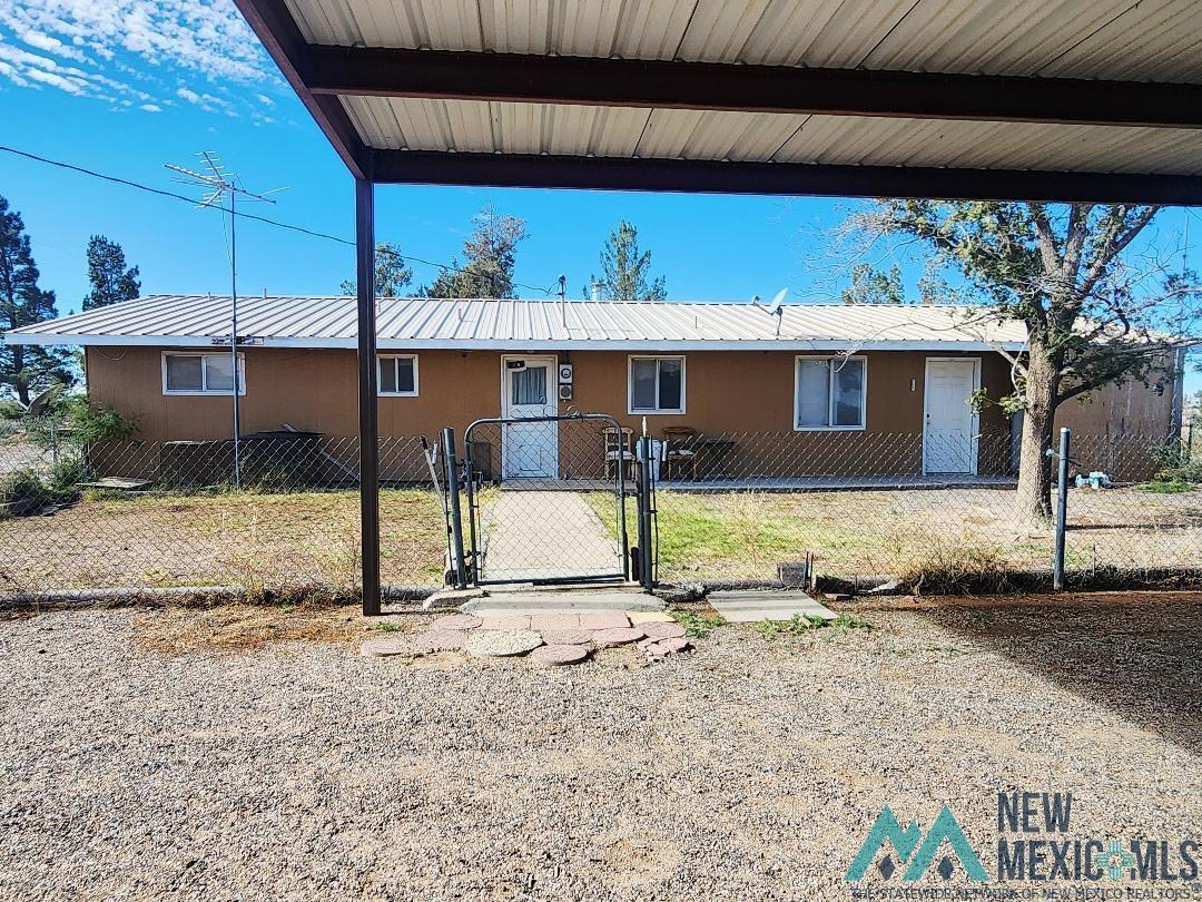 1890 El Portal Road Southeast Deming, NM 88030 - Photo 19 of 21 View of front of home featuring a gate, a fenced front yard, a metal roof, and stucco siding