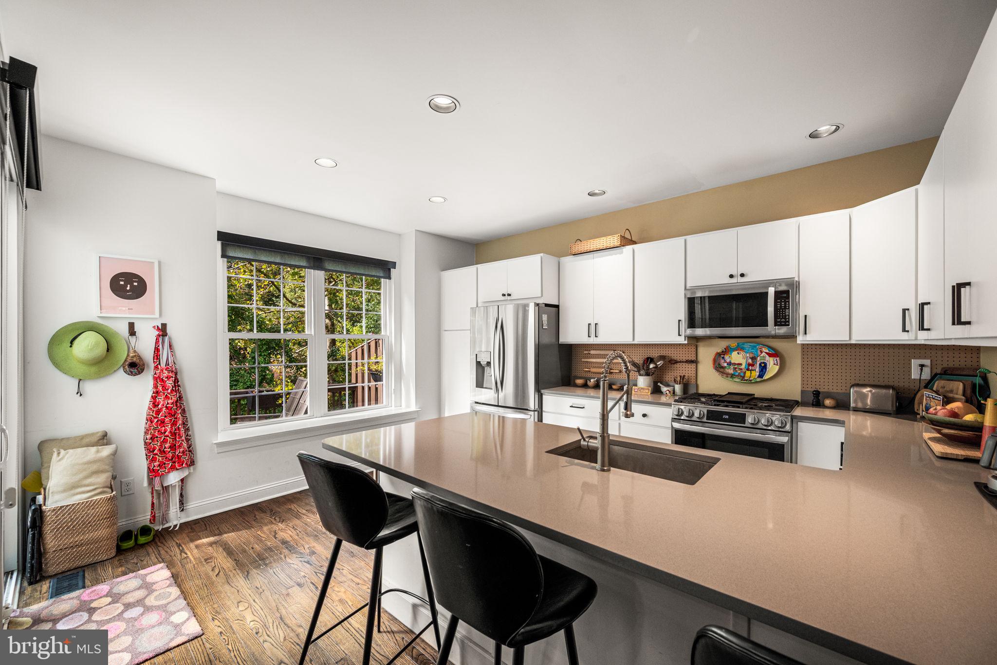 102 Dundee Mills Lane Wallingford, PA 19086 - Photo 16 of 43 a kitchen with stainless steel appliances a dining table chairs and granite counter tops