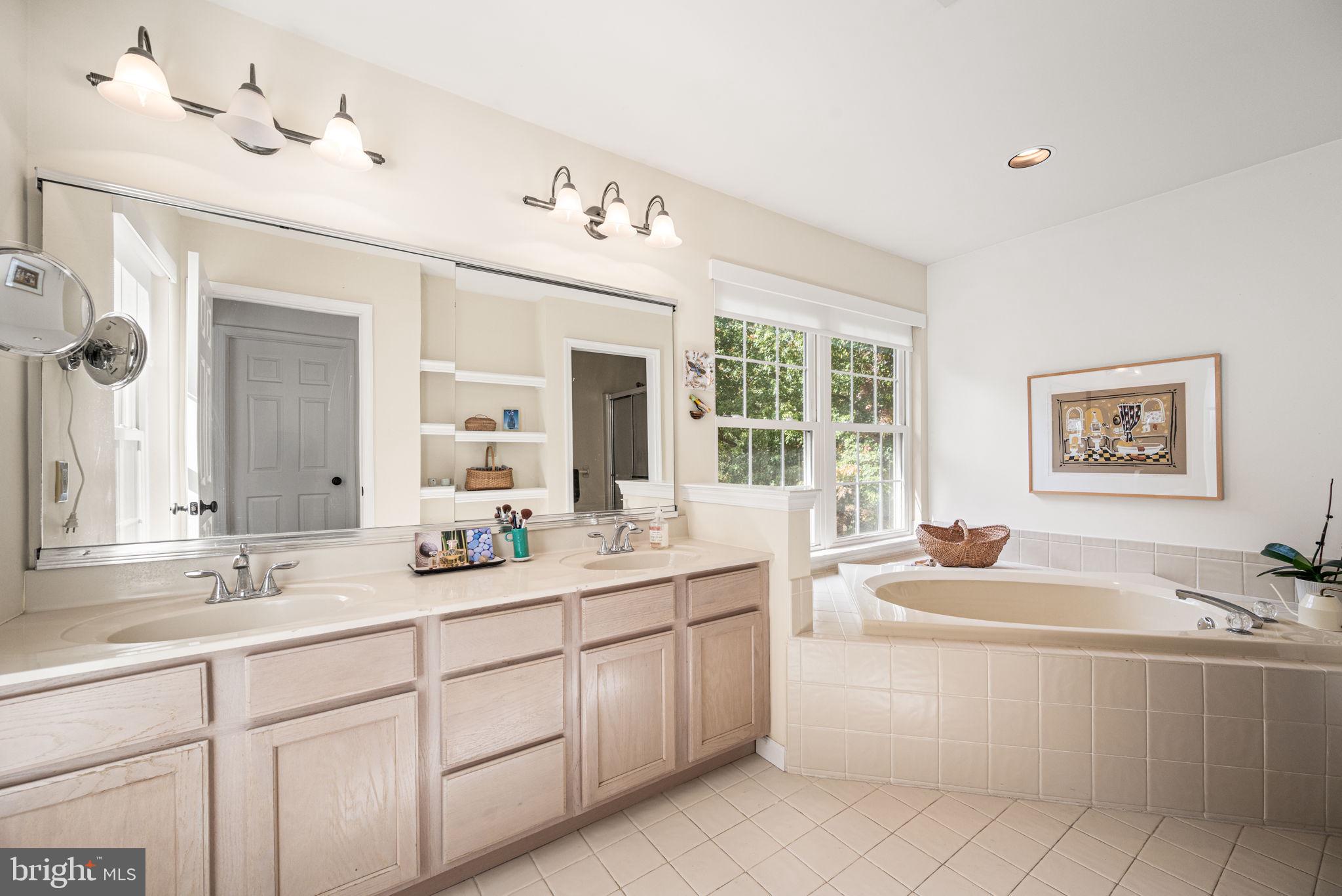 102 Dundee Mills Lane Wallingford, PA 19086 - Photo 24 of 43 a bathroom with a sink double vanity mirror and bathtub