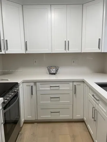 a kitchen with white cabinets and a sink