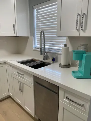 a kitchen with white cabinets and white appliances
