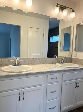a bathroom with a granite countertop sink double vanity and a mirror