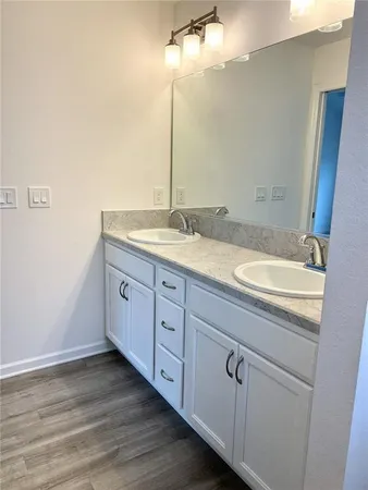 a bathroom with a granite countertop sink and a mirror