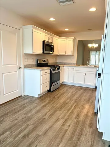 a kitchen with stainless steel appliances granite countertop a stove a sink and a refrigerator