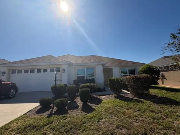 a view of a house with backyard and furniture