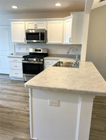 a kitchen with a sink a stove and microwave