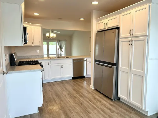 a kitchen with a refrigerator a sink and cabinets