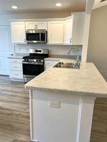 a kitchen with a sink a stove and microwave