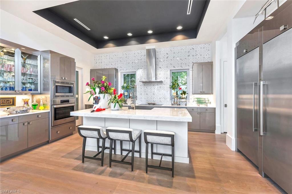 9193 Mercato Way Naples, FL 34108 - Photo 11 of 36 a kitchen with stainless steel appliances kitchen island granite countertop a table chairs sink and cabinets