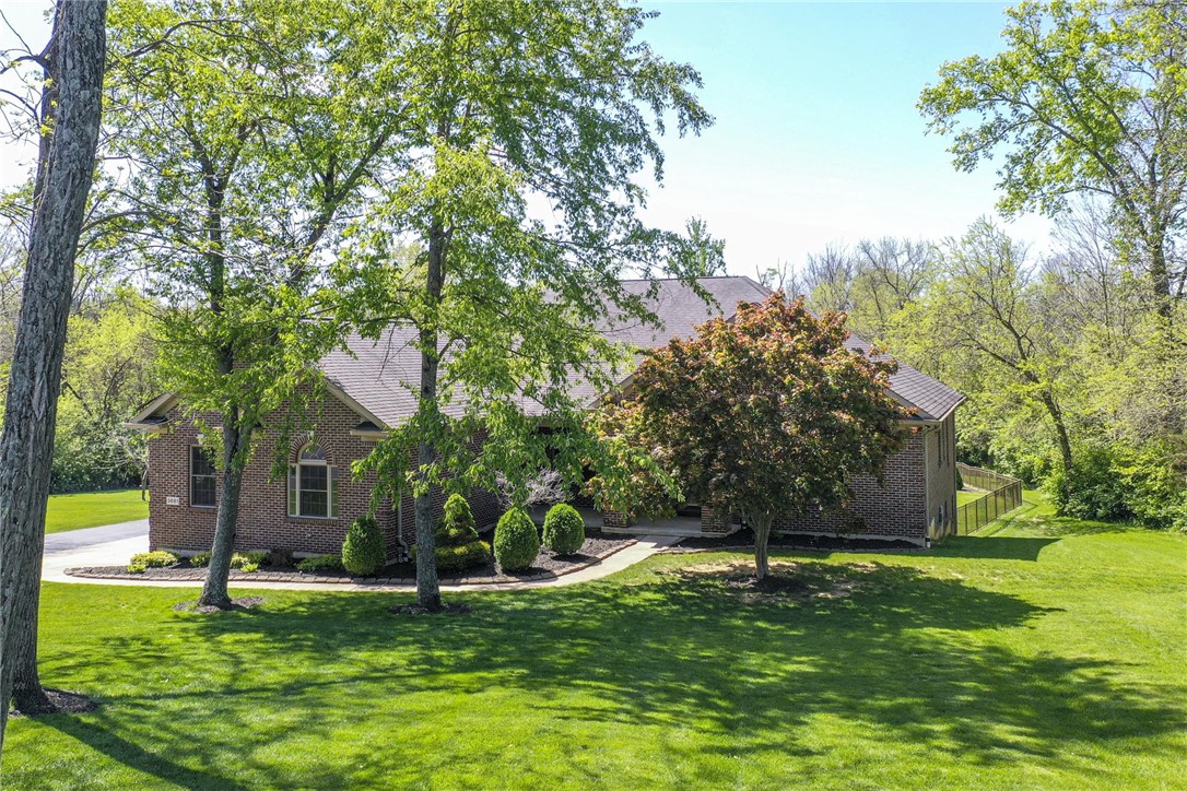 Lush landscaping surrounds this charming residence, creating a private outdoor retreat.