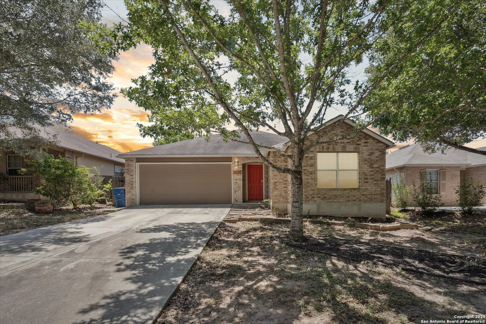 a front view of house with yard and trees around