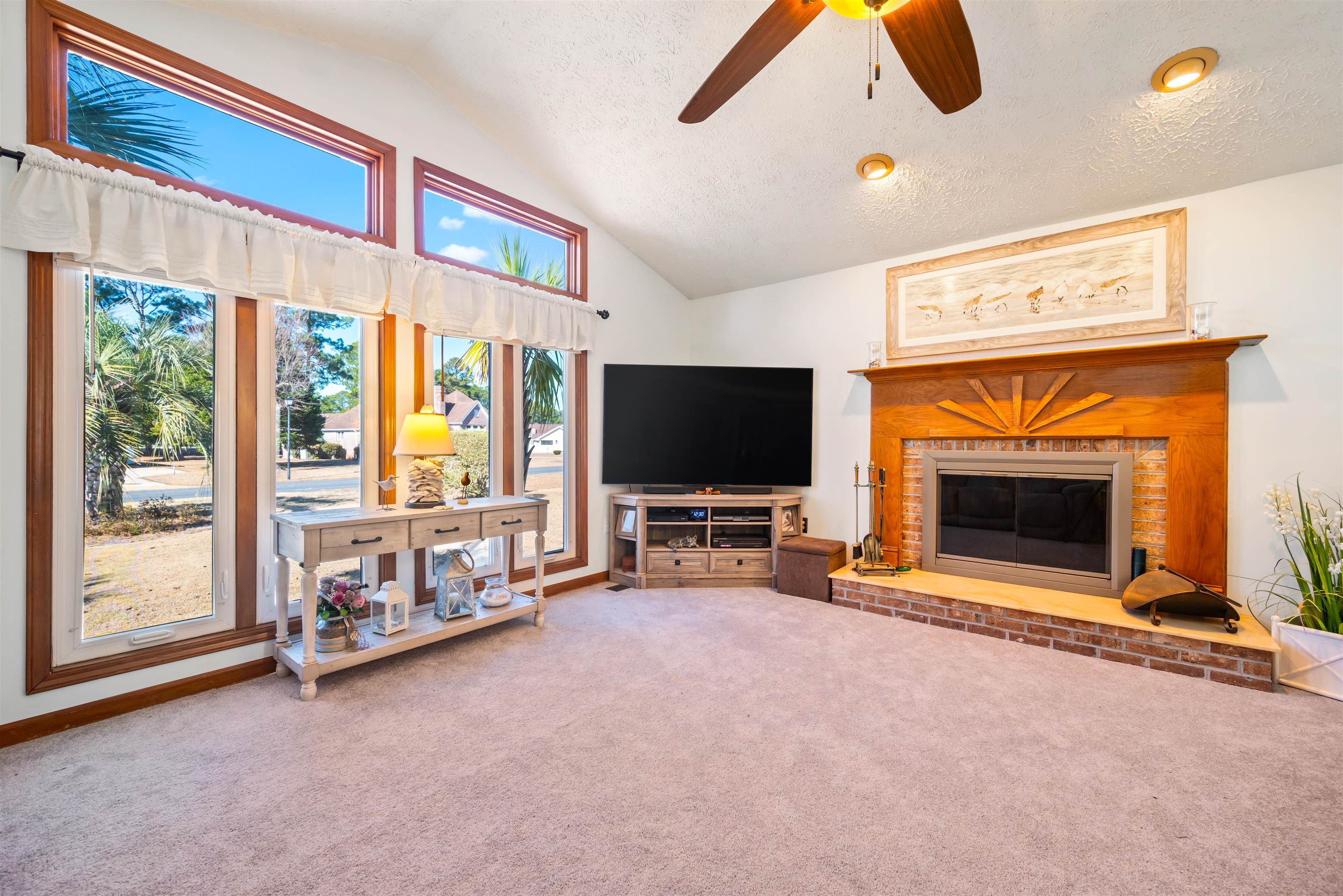 4746 National Drive Myrtle Beach, SC 29579 - Photo 12 of 40 Carpeted living area featuring a ceiling fan, vaulted ceiling, a brick fireplace, and a textured ceiling