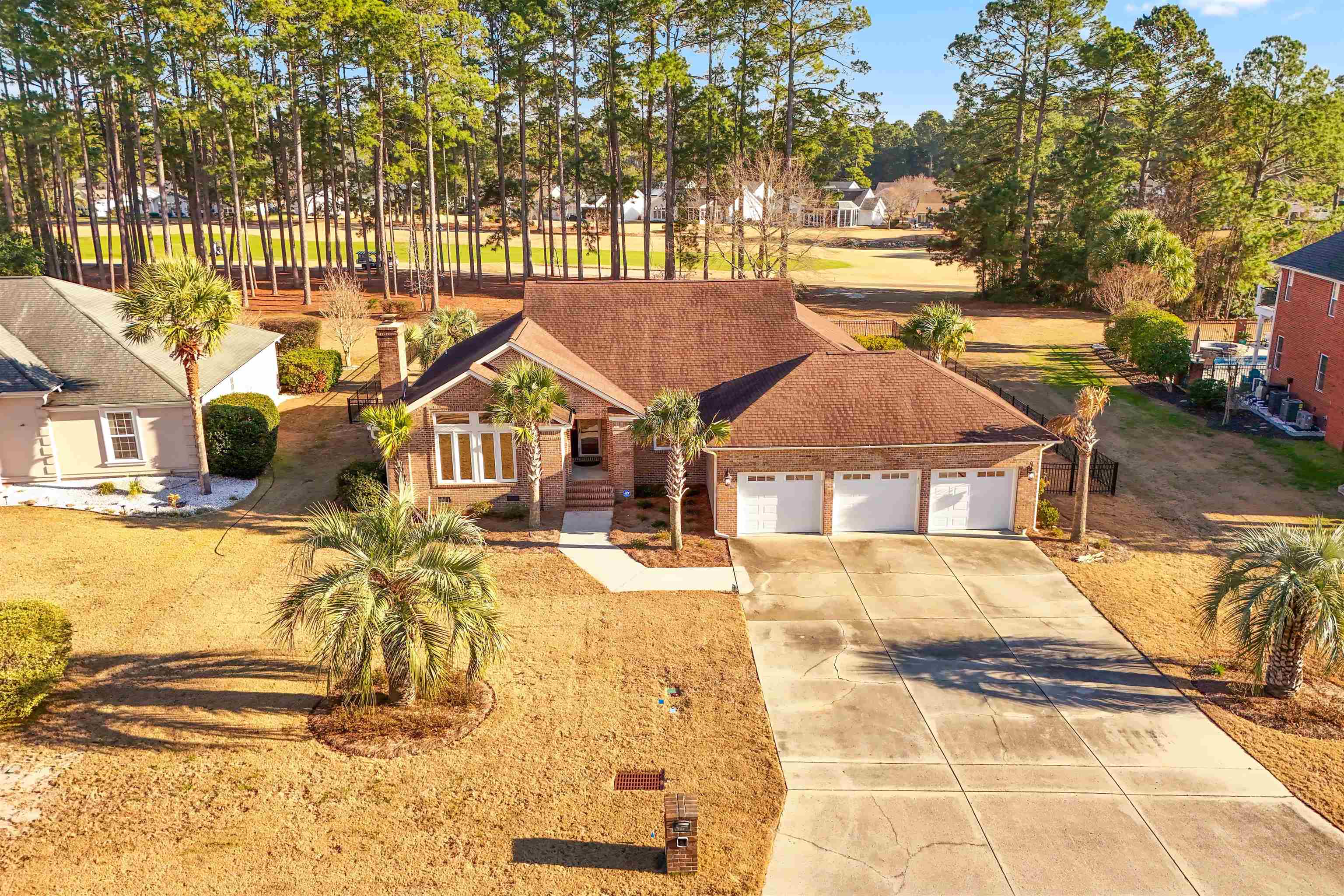 4746 National Drive Myrtle Beach, SC 29579 - Photo 2 of 40 View of front facade featuring brick siding, a garage, driveway, golf course view, and roof with shingles