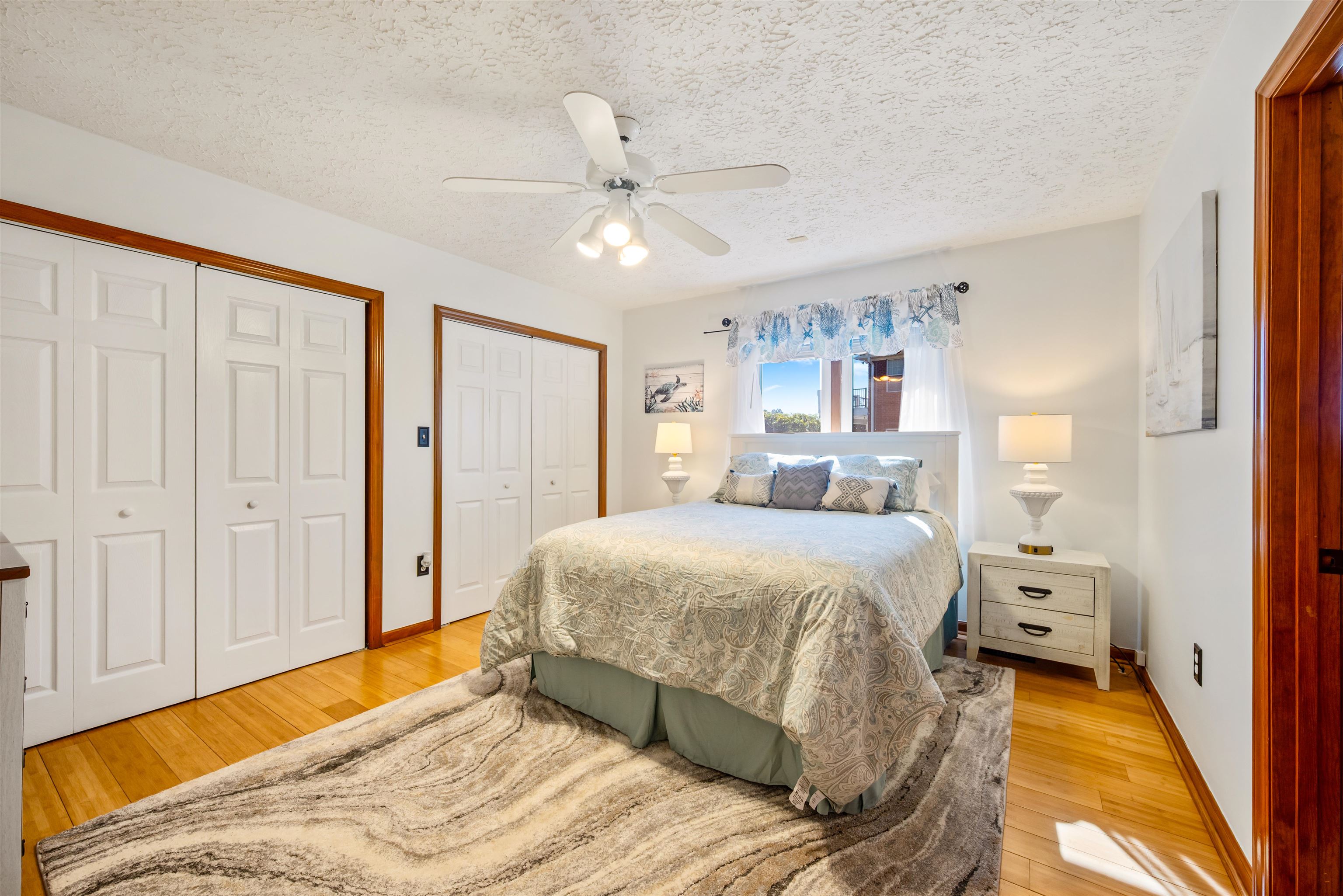 4746 National Drive Myrtle Beach, SC 29579 - Photo 23 of 40 Bedroom with multiple closets, light wood finished floors, a textured ceiling, and ceiling fan