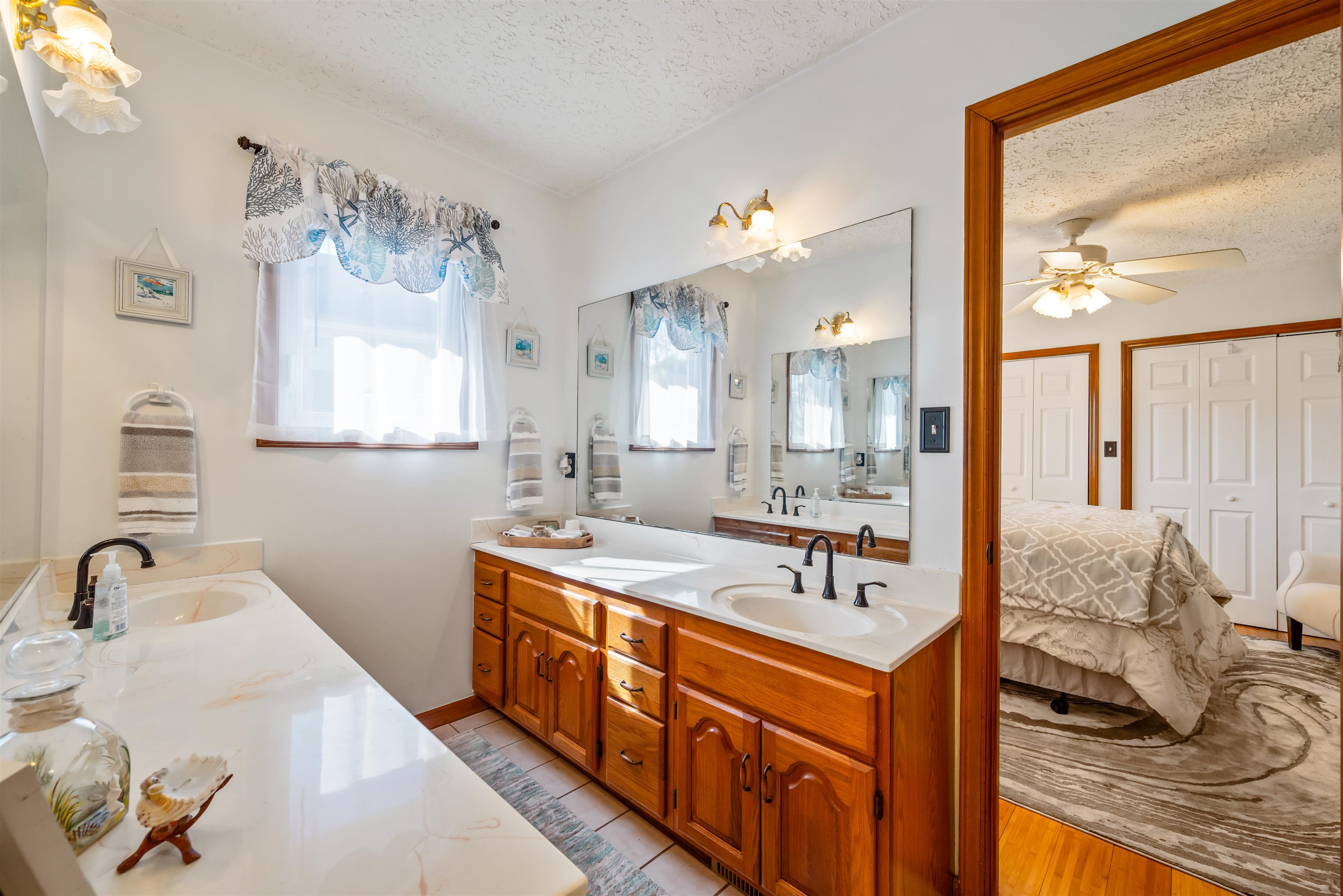 4746 National Drive Myrtle Beach, SC 29579 - Photo 25 of 40 Bathroom with double vanity, connected bathroom, a textured ceiling, and plenty of natural light