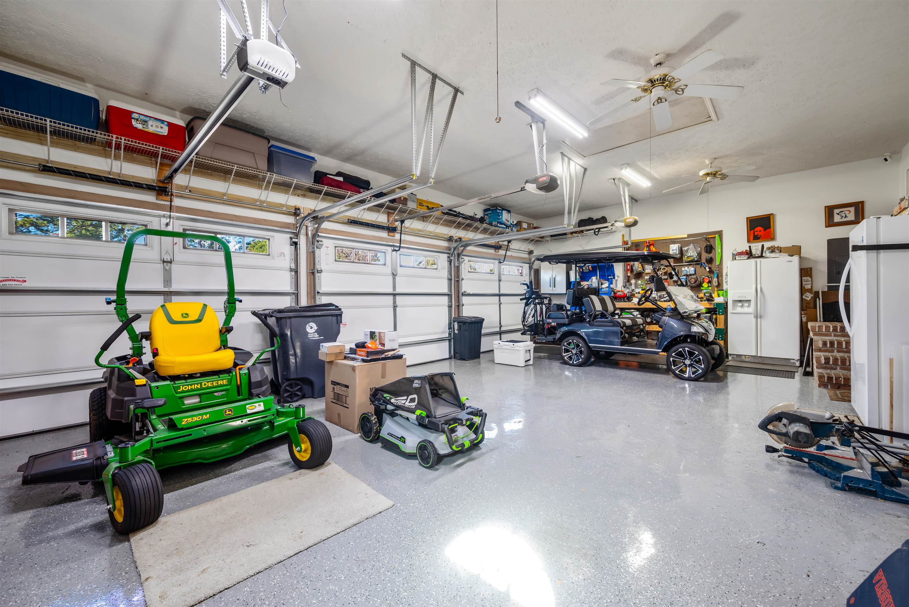 4746 National Drive Myrtle Beach, SC 29579 - Photo 31 of 40 Garage with white refrigerator with ice dispenser, freestanding refrigerator, a ceiling fan, and a garage door opener