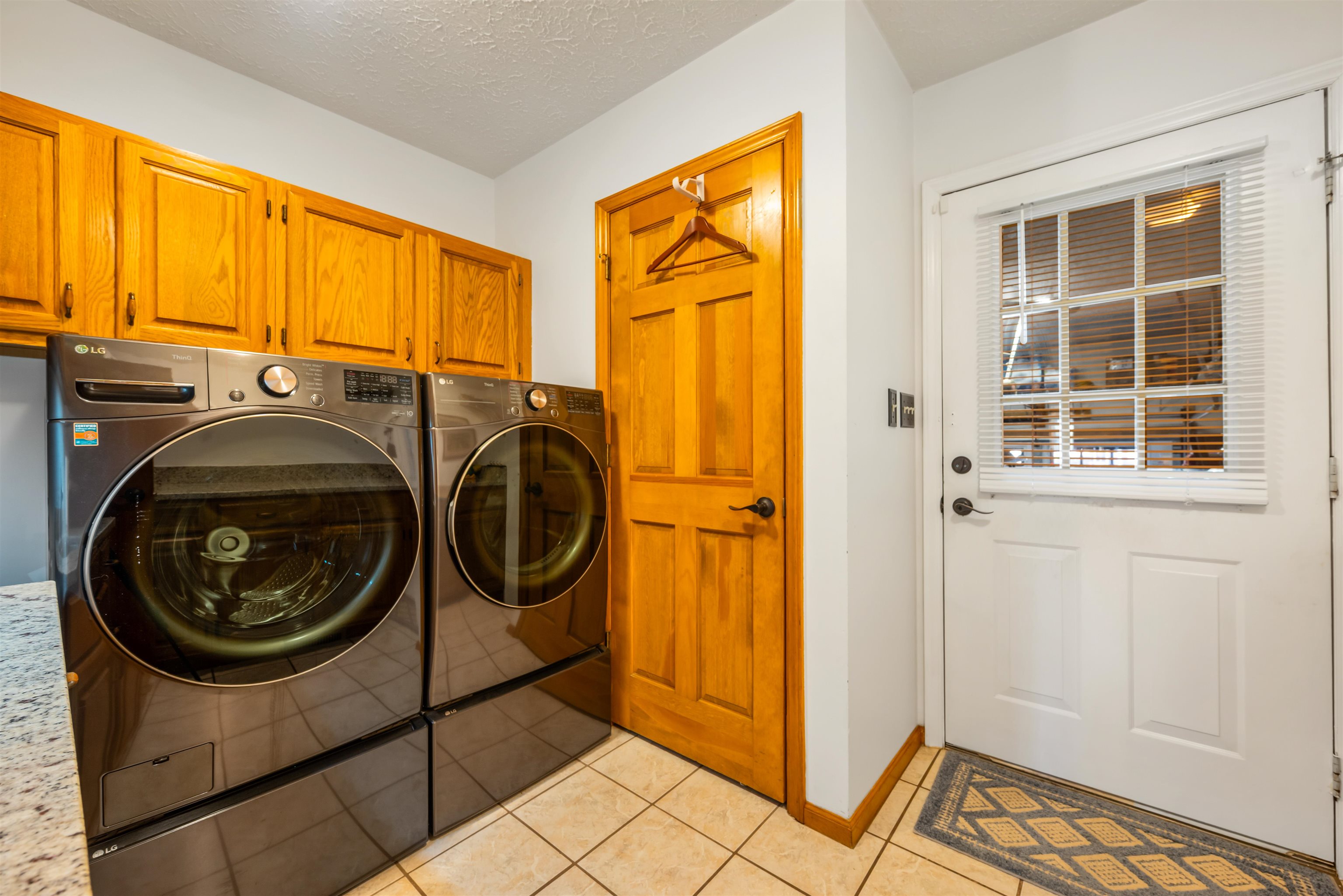 4746 National Drive Myrtle Beach, SC 29579 - Photo 32 of 40 Laundry area with a textured ceiling, light tile patterned floors, separate washer and dryer, and cabinet space
