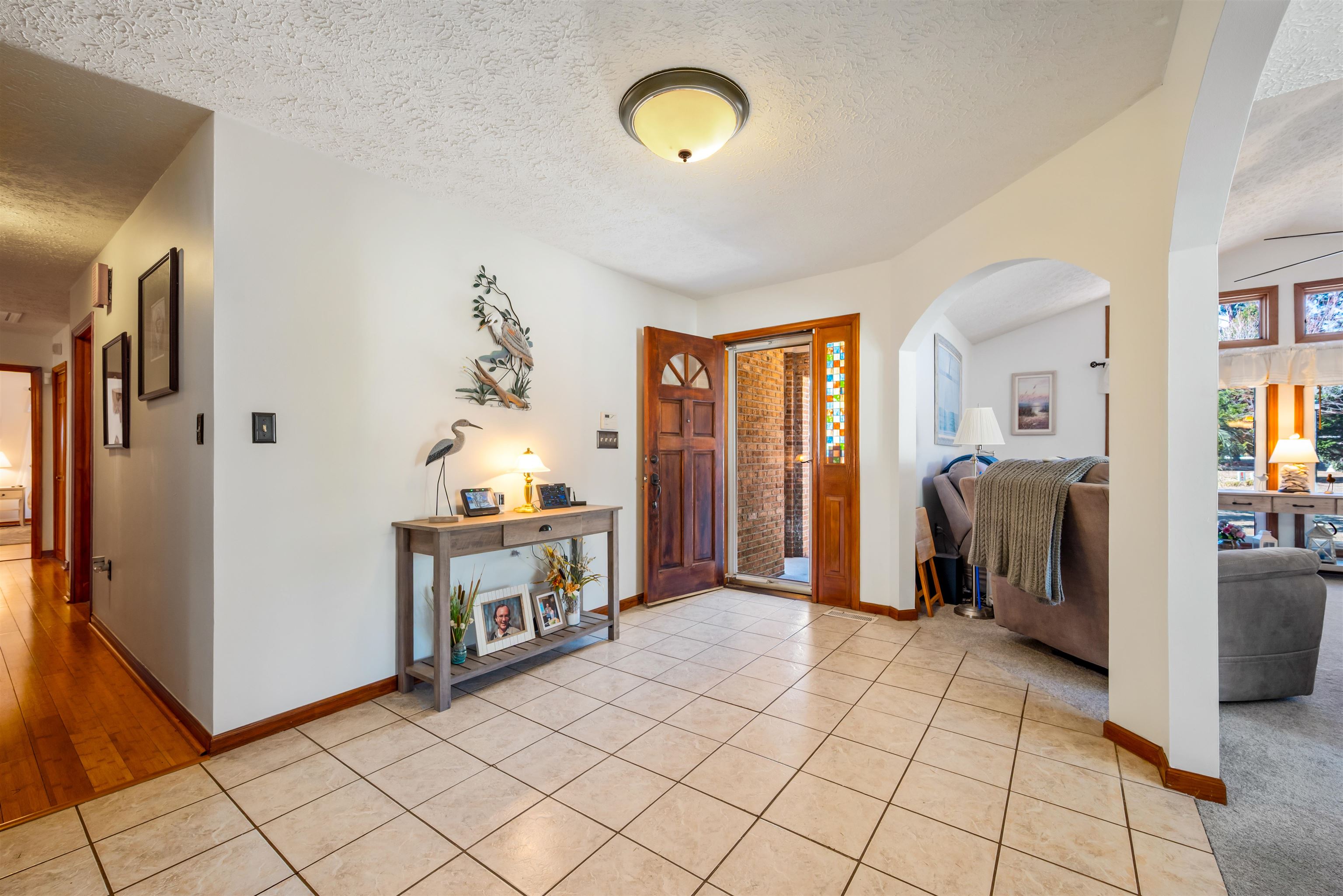 4746 National Drive Myrtle Beach, SC 29579 - Photo 4 of 40 Entryway with a textured ceiling, light tile patterned floors, arched walkways, and lofted ceiling