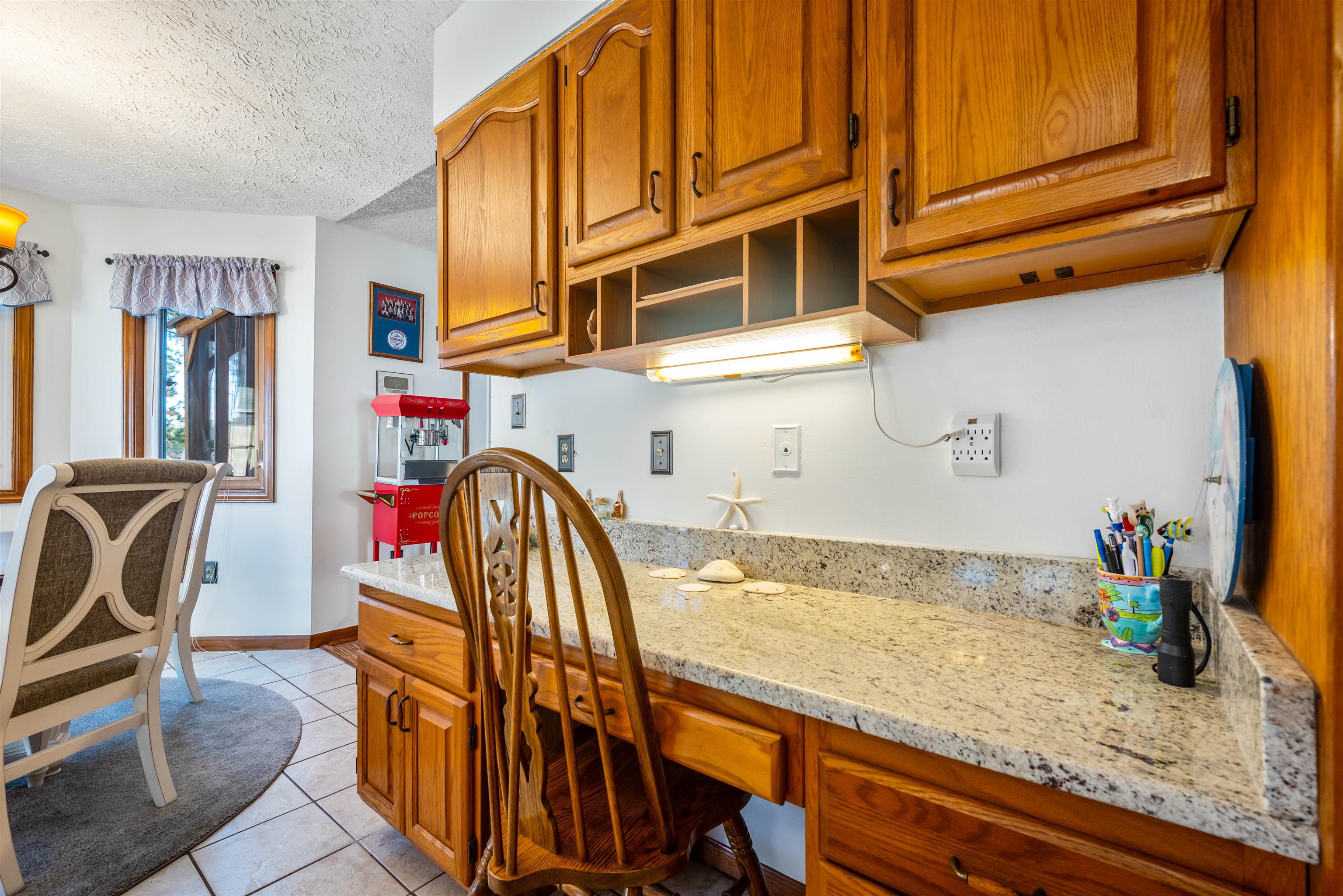 4746 National Drive Myrtle Beach, SC 29579 - Photo 7 of 40 Kitchen with brown cabinets, light stone counters, a textured ceiling, light tile patterned floors, and open shelves