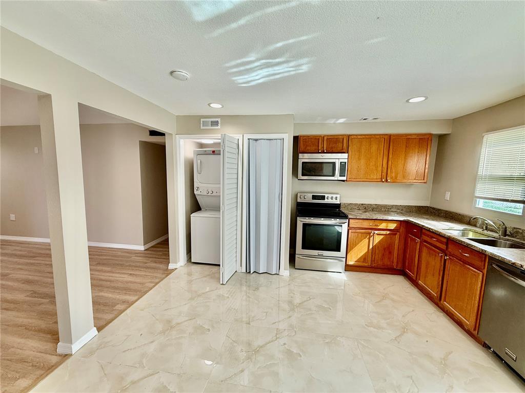 2769 L B McLeod Road, Unit 2769A Orlando, FL 32805 - Photo 6 of 15 a kitchen with stainless steel appliances granite countertop a refrigerator and a sink
