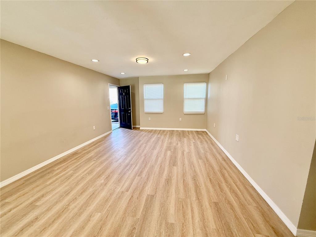 2769 L B McLeod Road, Unit 2769A Orlando, FL 32805 - Photo 8 of 15 a view of an empty room with wooden floor and a window