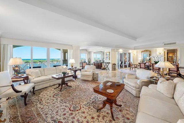 a living room with furniture a chandelier and a dining table