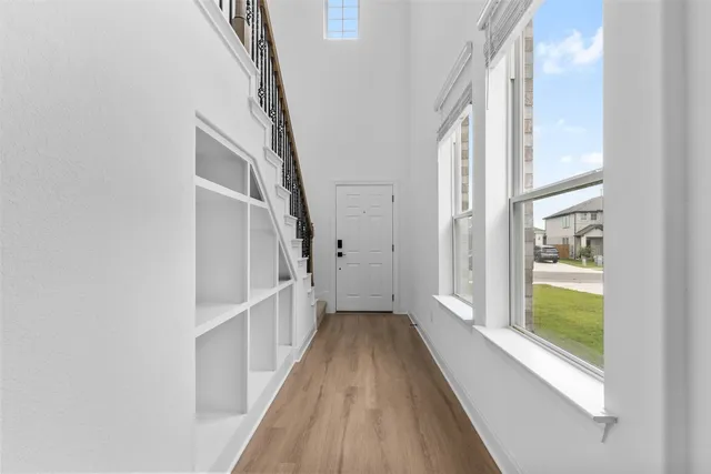 a view of a hallway with windows and stairs