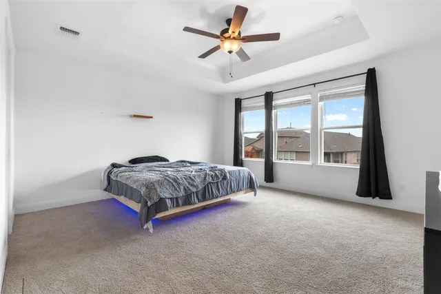 a bedroom with a bed and large windows