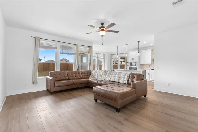a living room with furniture and a wooden floor