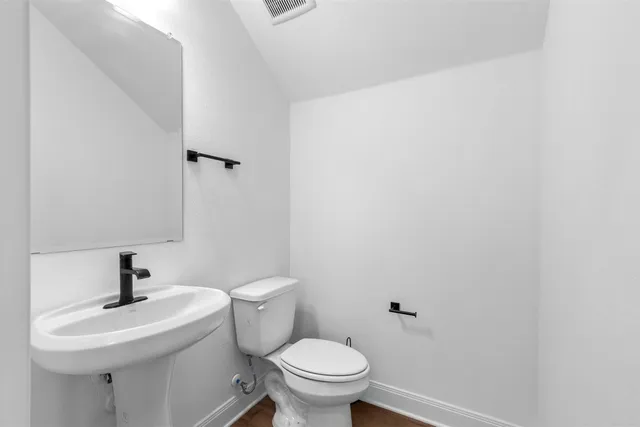 a bathroom with a toilet a sink and mirror