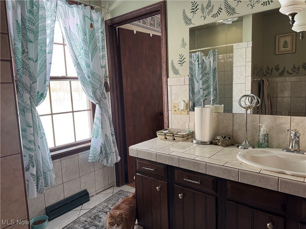 10004 Candy Road Cambridge, OH 43725 - Photo 10 of 20 Full bath featuring vanity, tile walls, and a shower with shower curtain