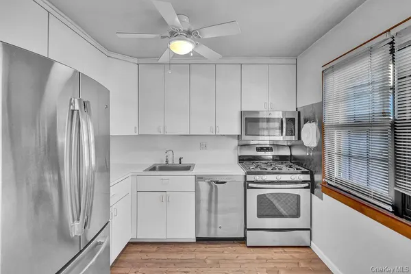 a kitchen with white cabinets and white appliances