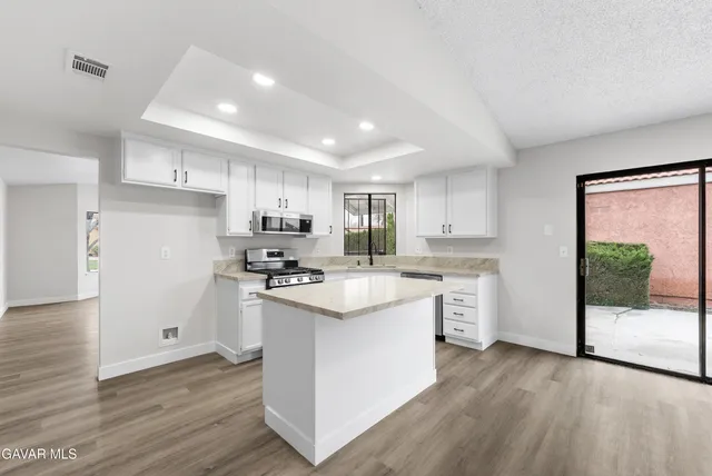 a kitchen with stainless steel appliances a sink stove top oven and cabinets