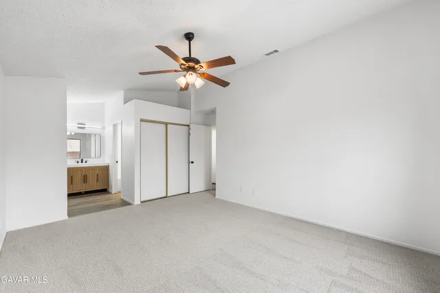 a view of a room with a ceiling fan and window