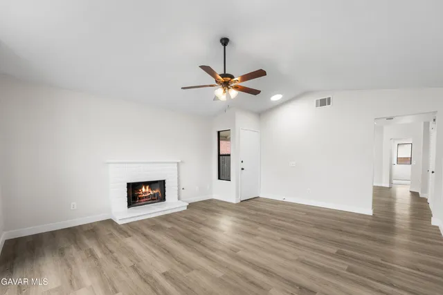 a view of a room with wooden floor and a ceiling fan