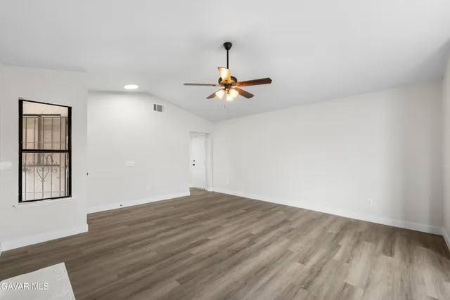 a view of an empty room with a fireplace and a window