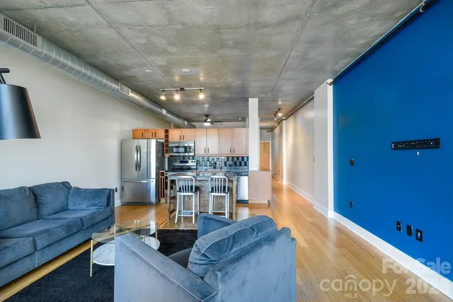 a living room with lots of furniture and kitchen view