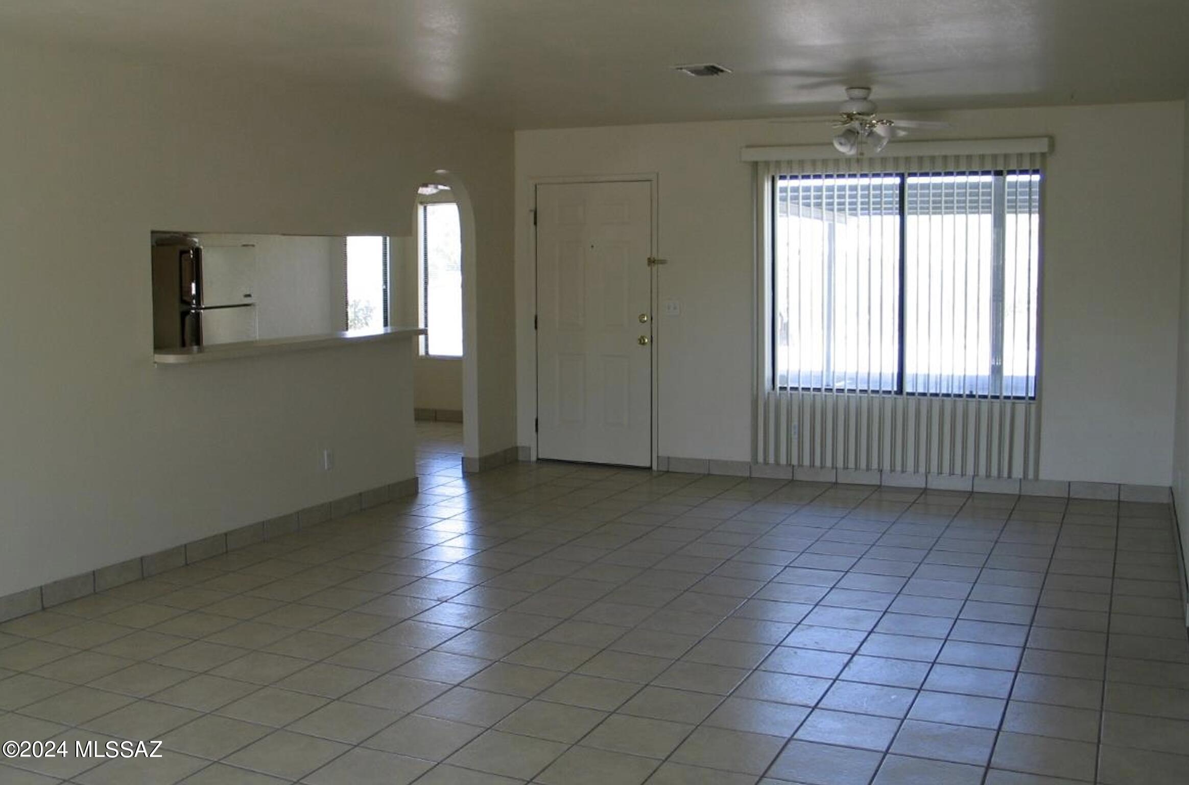 2118 North Ralph Avenue Tucson, AZ 85712 - Photo 6 of 10 an empty room with wooden floor and windows