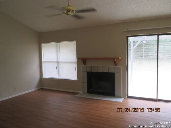 an empty room with windows and fireplace