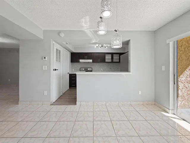 a view of a kitchen with a sink wooden cabinets and window