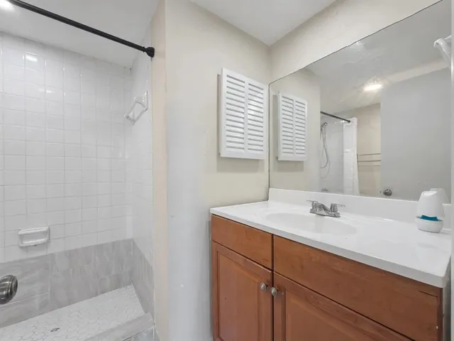 a bathroom with a sink a shower and a mirror