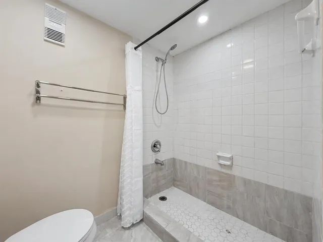 a bathroom with a shower a toilet and a shower