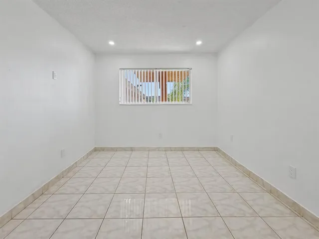 an empty room with white walls and tiles