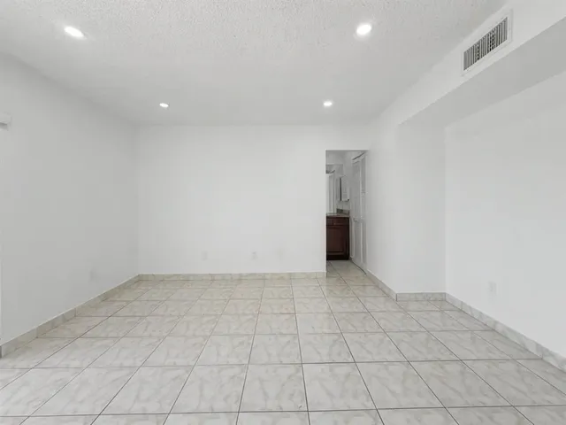 an empty room with white walls and natural light