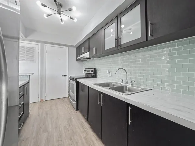 a kitchen with stainless steel appliances a sink stove and cabinets