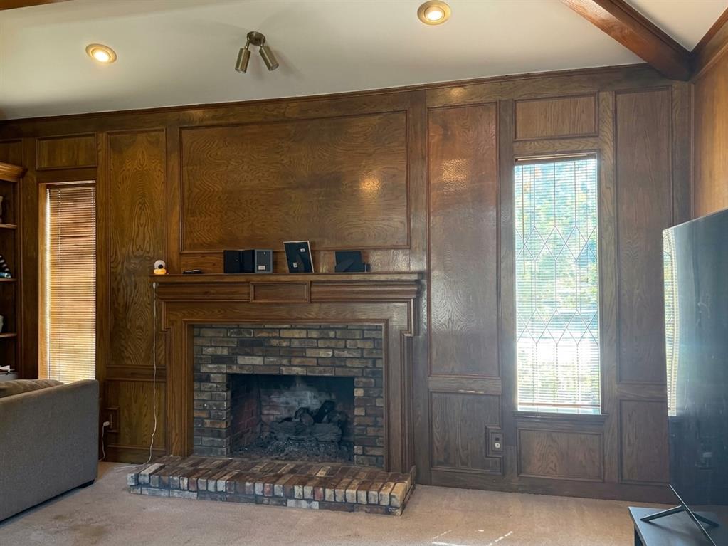 4307 Quail Hollow Road Dallas, TX 75287 - Photo 15 of 30 Living room with gas log fireplace and wood paneling